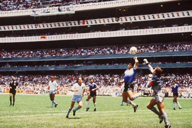Diego Maradona surpasse le gardien anglais Peter Shilton pour marquer avec son but `` Main de Dieu '' lors du quart de finale de la Coupe du monde 1986 contre l'Angleterre au stade Azteca de Mexico. Photographie: Bongarts