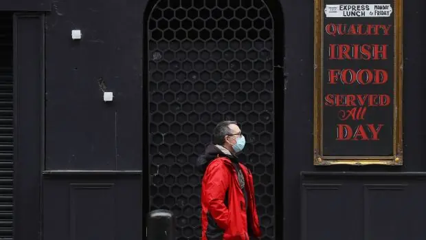 Un homme passe devant un pub fermé dans le centre-ville de Dublin Le gouvernement doit examiner mardi les nouveaux conseils de l'équipe nationale des urgences de santé publique (Nphet) concernant les nouvelles restrictions en matière d'hospitalité et de visites à domicile. Photographie: PA