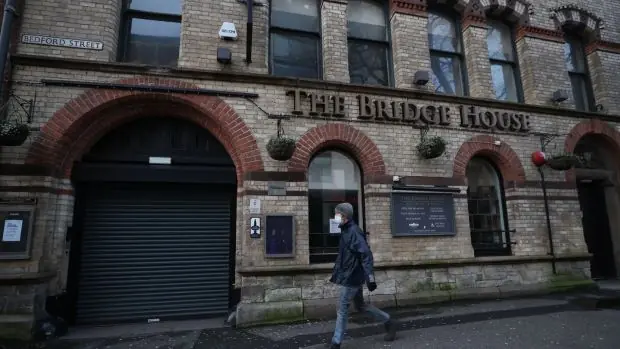 Un homme vêtu d'un masque passe devant le Bridge House Pub fermé à Belfast cette semaine pendant le verrouillage continu de l'Irlande du Nord pour lutter contre le coronavirus. Photographie de dossier: Liam McBurney / PA Wire